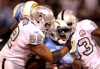 OAKLAND, CA - SEPTEMBER 14:  LaDainian Tomlinson #21 of the San Diego Chargers is tackled by Richard Seymour #92 of the Oakland Raiders during their game on September 14, 2009 at the Oakland-Alameda County Coliseum in Oakland, California.  (Photo by Ezra Shaw/Getty Images)
