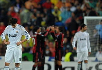 MADRID, SPAIN - OCTOBER 21:  Kaka (L) of Real Madrid stands dejected after conceding a goal as AC Milan players celebrate in the background during the Champions League group C match between Real Madrid and AC Milan at the Estadio Santiago Bernabeu on October 21, 2009 in Madrid, Spain. AC Milan won the match 3-2.  (Photo by Jasper Juinen/Getty Images)