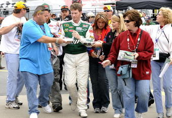 CONCORD, NC - OCTOBER 16:  Dale Earnhardt Jr driver of the #88 AMP Energy/National Guard Chevrolet, signs autographs for fans as he walks to his car before practice for the NASCAR Sprint Cup Series NASCAR Banking 500 at Lowe's Motor Speedway on October 16, 2009 in Concord, North Carolina.  (Photo by John Harrelson/Getty Images for NASCAR)