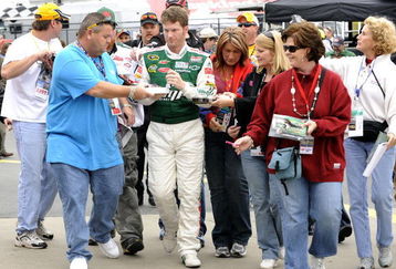 CONCORD, NC - OCTOBER 16:  Dale Earnhardt Jr driver of the #88 AMP Energy/National Guard Chevrolet, signs autographs for fans as he walks to his car before practice for the NASCAR Sprint Cup Series NASCAR Banking 500 at Lowe's Motor Speedway on October 16, 2009 in Concord, North Carolina.  (Photo by John Harrelson/Getty Images for NASCAR)