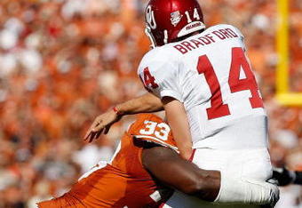 DALLAS - OCTOBER 17:  Quarterback Sam Bradford #14 of the Oklahoma Sooners is tackled by Lamarr Houston #33 of the Texas Longhorns at Cotton Bowl on October 17, 2009 in Dallas, Texas.  (Photo by Ronald Martinez/Getty Images)