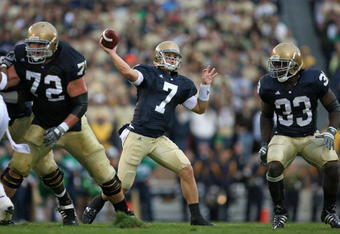 SOUTH BEND, IN - OCTOBER 03: Jimmy Clausen #7 of the Notre Dame Fighting Irish passes the ball as teammates Paul Duncan #72 and Robert Hughes #33 look to block against the Washington Huskies on October 3, 2009 at Notre Dame Stadium in South Bend, Indiana. Notre Dame defeated Washington 37-30 in overtime. (Photo by Jonathan Daniel/Getty Images)