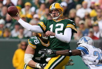 GREEN BAY, WI - OCTOBER 18: Aaron Rodgers #12 of the Green Bay Packers leaps to throw a pass under pressure from Kevin Hobbs #23 of the Detroit Lions at Lambeau Field on October 18, 2009 in Green Bay, Wisconsin. The Packers defeated the Lions 26-0.  (Photo by Jonathan Daniel/Getty Images)
