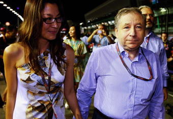 SINGAPORE - SEPTEMBER 27:  F.I.A. Presidential candidate Jean Todt and Michelle Yeoh walk on the grid before the Singapore Formula One Grand Prix at the Marina Bay Street Circuit on September 27, 2009 in Singapore.  (Photo by Mark Thompson/Getty Images)