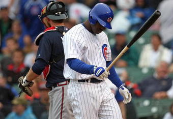 CHICAGO - JULY 08: Milton Bradley #21 of the Chicago Cubs walks back to the dugout after making the final out of the game as Brian McCann #16 of the Atlanta Braves walks to the mound on July 8, 2009 at Wrigley Field in Chicago, Illinois. The Braves defeated the Cubs 4-1. (Photo by Jonathan Daniel/Getty Images)