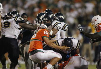 MIAMI - OCTOBER 14:  Chris Smith #26 and Marshall McDuffie Jr. #24 of the Florida International Panthers fight Ross Abramson #86 of the Miami Hurricanes during an on field fight at the Orange Bowl on October 14, 2006 in Miami, Florida. Miami won 35-0.  (Photo by Marc Serota/Getty Images)