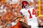 DALLAS - OCTOBER 17:  Quarterback Sam Bradford #14 of the Oklahoma Sooners is tackled by Lamarr Houston #33 of the Texas Longhorns at Cotton Bowl on October 17, 2009 in Dallas, Texas.  (Photo by Ronald Martinez/Getty Images)