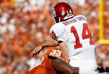 DALLAS - OCTOBER 17:  Quarterback Sam Bradford #14 of the Oklahoma Sooners is tackled by Lamarr Houston #33 of the Texas Longhorns at Cotton Bowl on October 17, 2009 in Dallas, Texas.  (Photo by Ronald Martinez/Getty Images)