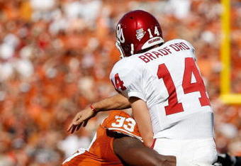 DALLAS - OCTOBER 17:  Quarterback Sam Bradford #14 of the Oklahoma Sooners is tackled by Lamarr Houston #33 of the Texas Longhorns at Cotton Bowl on October 17, 2009 in Dallas, Texas.  (Photo by Ronald Martinez/Getty Images)