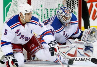 MONTREAL- OCTOBER 24: Daniel Girardi #5 gets down to lcear the puck from in front of Henrik Lundqvist #30 of the New York Rangers during the NHL game against the Montreal Canadiens on October 24, 2009 at the Bell Centre in Montreal, Quebec, Canada. (Photo by Richard Wolowicz/Getty Images)