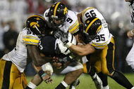 STATE COLLEGE, PA - SEPTEMBER 26: Evan Royster #22 of the Penn State Nittnay Lions is tackled by Karl Klug #95, Tyler Sash #9, and Broderick Binns #91 of the Iowa Hawkeye's on September 26, 2009 at Beaver Stadium in State College, Pennsylvania. Iowa won the game 21-10 (Photo by Gregory Shamus/Getty Images)