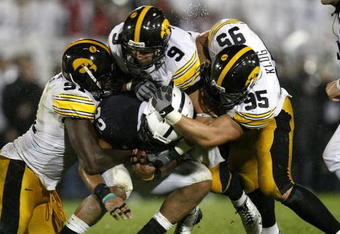 STATE COLLEGE, PA - SEPTEMBER 26:  Evan Royster #22 of the Penn State Nittnay Lions is tackled by Karl Klug #95, Tyler Sash #9, and Broderick Binns #91 of the Iowa Hawkeye's on September 26, 2009 at Beaver Stadium in State College, Pennsylvania. Iowa won the game 21-10 (Photo by Gregory Shamus/Getty Images)