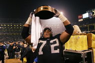 OAKLAND, CA - JANUARY 19:  Tackle Lincoln Kennedy #72 of the Oakland Raiders holds up the Lamar Hunt Trophy after the 41-24 victory over the Tennessee Titans in the AFC Championship Game at Network Associates Coliseum on January 19, 2003 in Oakland, California.  The Raiders have moved on to the NFL title game for the first time since 1984.  (Photo by Stephen Dunn/Getty Images)