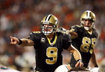 MIAMI - OCTOBER 25:  Quarterback Drew Brees #9 of the New Orleans Saints directs his offense pre-snap against the Miami Dolphins at Land Shark Stadium on October 25, 2009 in Miami, Florida. The Saints defeated the Dolphins 46-34.  (Photo by Doug Benc/Getty Images)