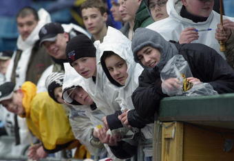 CHICAGO - APRIL 4: Fans peer over the wall into the Chicago White Sox dugout during a rain delay for the home opener against the Detroit Tigers on April 4, 2003 at U.S. Cellular Field in Chicago, Illinois.  (Photo by Jonathan Daniel/Getty Images)
