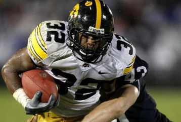 STATE COLLEGE, PA - SEPTEMBER 26:  Adam Robinson #32 of the Iowa Hawkeyes runs for a fourth quarter touchdown trough the tackle of Josh Hull #43 of the Penn State Nittnay Lions on September 26, 2009 at Beaver Stadium in State College, Pennsylvania. Iowa won the game 21-10. (Photo by Gregory Shamus/Getty Images)