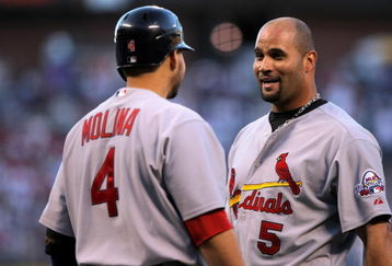 DENVER - SEPTEMBER 26:  Albert Pujols #5 of the St. Louis Cardinals is welcomed home by Yadier Molina #4 after Pujols scored in the first inning against the Colorado Rockies at Coors Field on September 26, 2009 in Denver, Colorado. The Cardinals clinched the National League Central Division when they defeated the Rockies 6-3.  (Photo by Doug Pensinger/Getty Images)