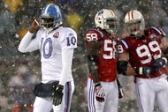 FOXBORO - OCTOBER 18:  Vince Young #10 of the Tennessee Titans leaves the field as Pierre Woods #58 and Mike Wright #99 of the New England Patriots converse at Gillette Stadium on October 18, 2009 in Foxboro, Massachusetts. The Patriots won 59-0. (Photo by Jim Rogash/Getty Images)