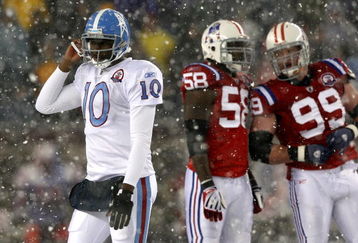 FOXBORO - OCTOBER 18:  Vince Young #10 of the Tennessee Titans leaves the field as Pierre Woods #58 and Mike Wright #99 of the New England Patriots converse at Gillette Stadium on October 18, 2009 in Foxboro, Massachusetts. The Patriots won 59-0. (Photo by Jim Rogash/Getty Images)