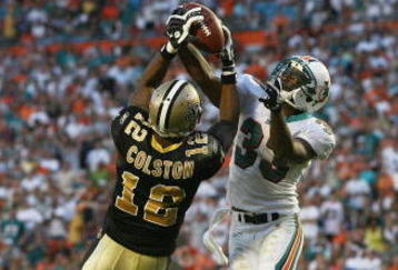 MIAMI - OCTOBER 25:  Cornerback Nathan Jones #33 of the Miami Dolphins takes a pass away from wide receiver Marques Colston #12 of the New Orleans Saints at Land Shark Stadium on October 25, 2009 in Miami, Florida. The Saints defeated the Dolphins 46-34.  (Photo by Doug Benc/Getty Images)