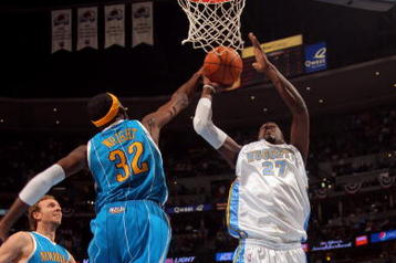 DENVER - APRIL 22:  Johan Petro #27 of the Denver Nuggets tries to get off a shot against Julian Wright #32 of the New Orleans Hornets in Game Two of the Western Conference Quarterfinals during the 2009 NBA Playoffs at Pepsi Center on April 22, 2009 in Denver, Colorado. The Nuggets defeated the Hornets 108-93. NOTE TO USER: User expressly acknowledges and agrees that, by downloading and or using this photograph, User is consenting to the terms and conditions of the Getty Images License Agreement.  (Photo by Doug Pensinger/Getty Images)