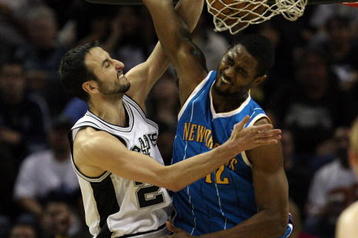 SAN ANTONIO - JANUARY 31:  Guard Manu Ginobili #20 of the San Antonio Spurs slams the ball over Hilton Armstrong #12 of the New Orleans Hornets on January 31, 2009 at AT&T Center in San Antonio, Texas.  NOTE TO USER: User expressly acknowledges and agrees that, by downloading and/or using this Photograph, user is consenting to the terms and conditions of the Getty Images License Agreement.  (Photo by Ronald Martinez/Getty Images)