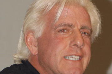 GARDEN CITY, NY - MARCH 3:  World Wrestling Entertainment (WWE) professional wrestler Ric Flair speaks on a panel during the 'Professor For A Day' event at Nassau Community College March 3, 2003 in Garden City, New York. Flair acted as an assistant professor to WWE CEO Linda McMahon, who lectured a group of sports marketing majors on the marketing and promotional strategies that have made the WWE a long-term success.  (Photo By Steven Henry/Getty Images)