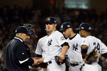 NEW YORK - OCTOBER 28:  Manager Joe Girardi (L) of the New York Yankees takes Phil Hughes #65 out of the game in the top of the eighth inning against the Philadelphia Phillies in Game One of the 2009 MLB World Series at Yankee Stadium on October 28, 2009 in the Bronx borough of New York City.  (Photo by Jim McIsaac/Getty Images)