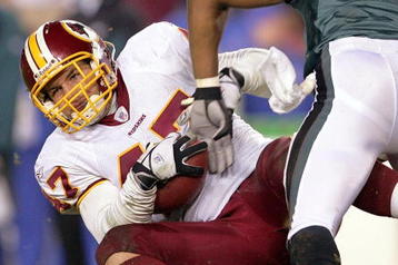 LANDOVER, MD - DECEMBER 12:  Safety Michael Lewis #32 of the Philadelphia Eagles hits tight end Chris Cooley #47 of the Washington Redskins during the second half of the game at Fed Ex Field on December 12, 2004 in Landover, Maryland.  (Photo by Jamie Squire/Getty Images)