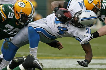 GREEN BAY, WI - OCTOBER 18:  Kevin Smith #34 of the Detroit Lions is tackled by Ryan Pickett #79 and A.J. Hawk #50 of the Green Bay Packers at Lambeau Field on October 18, 2009 in Green Bay, Wisconsin. The Packers defeated the Lions 26-0. (Photo by Jonathan Daniel/Getty Images)