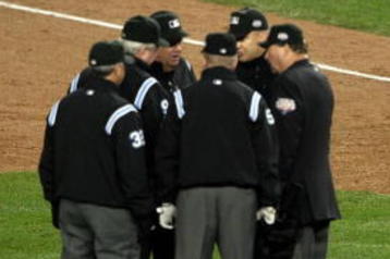 NEW YORK - OCTOBER 28:  The Umpire crew dicuss a call on a ball hit by Robinson Cano #24 (2nd R) of the New York Yankees as Cano and first base coach Mick Kelleher #50 looks on in the bottom of the fifth inning against the of the Philadelphia Phillies in Game One of the 2009 MLB World Series at Yankee Stadium on October 28, 2009 in the Bronx borough of New York City.  (Photo by Nick Laham/Getty Images)