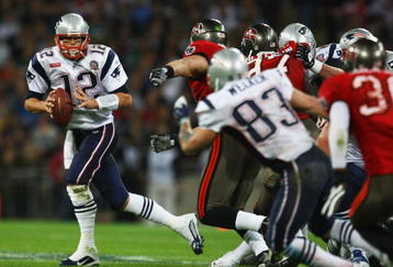 LONDON, ENGLAND - OCTOBER 25:  Tom Brady (#12) of the New England Patriots runs with the ball during the NFL International Series match between New England Patriots and Tampa Bay Buccaneers at Wembley Stadium on October 25, 2009 in London, England. This is the third occasion where a regular season NFL match has been played in London.  (Photo by Julian Finney/Getty Images)