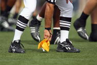MADISON, WI - SEPTEMBER 26: A referee picks up a yellow flag during the game between the Wisconsin Badgers and the Michigan State Spartans on September 26, 2009 at Camp Randall Stadium in Madison, Wisconsin. Wisconsin defeated Michigan State 38-30. (Photo by Jonathan Daniel/Getty Images)