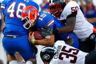 JACKSONVILLE, FL - OCTOBER 31:  Quarterback Tim Tebow #15 of the Florida Gators scores a touchdown against Rennie Curran #35 and Darryl Gamble #50 of the Georgia Bulldogs at Jacksonville Municipal Stadium on October 31, 2009 in Jacksonville, Florida.  (Photo by Kevin C. Cox/Getty Images)