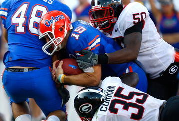 JACKSONVILLE, FL - OCTOBER 31:  Quarterback Tim Tebow #15 of the Florida Gators scores a touchdown against Rennie Curran #35 and Darryl Gamble #50 of the Georgia Bulldogs at Jacksonville Municipal Stadium on October 31, 2009 in Jacksonville, Florida.  (Photo by Kevin C. Cox/Getty Images)