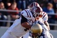 ANNAPOLIS, MD - NOVEMBER 19:  In this handout from the U.S. Navy, U.S. Naval Academy Midshipman full back Adam Ballard #22 is tackled by Temple Owls defender Justin Johnson #4 during the 1st quarter of play on November 19, 2005 at Navy Memorial Stadium in Annapolis, Maryland.  (Photo by Damon J. Moritz/U.S. Navy via Getty Images)