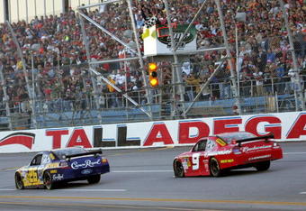 TALLADEGA, AL - NOVEMBER 01: Jamie McMurray, driver of the #26 IRWIN Marathon Ford, takes the checkered flag ahead of second place finisher Kasey Kahne, driver of the #9 Budweiser Dodge to win the NASCAR Sprint Cup Series AMP Energy 500 at Talladega Superspeedway on November 1, 2009 in Talladega, Alabama.  (Photo by Jerry Markland/Getty Images for NASCAR)