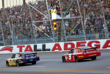 TALLADEGA, AL - NOVEMBER 01: Jamie McMurray, driver of the #26 IRWIN Marathon Ford, takes the checkered flag ahead of second place finisher Kasey Kahne, driver of the #9 Budweiser Dodge to win the NASCAR Sprint Cup Series AMP Energy 500 at Talladega Superspeedway on November 1, 2009 in Talladega, Alabama.  (Photo by Jerry Markland/Getty Images for NASCAR)
