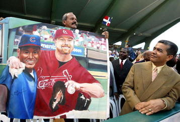 SAN JUAN, PUERTO RICO - SEPTEMBER 9:  ***PUERTO RICO OUT***INTERNET OUT**  Orlando Doble, a native of San Pedro de Macoris in the Domincan Republic, carries a painting of Sammy Sosa #21 of the Chicago Cubs and former St. Louis Cardinal Mark McGwire prior to the Cubs game against the Montreal Expos September 9, 2003 at Hiram Bithorn Stadium in San Juan, Puerto Rico. This is Sosa's first appearance on the island as a member of the Chicago Cubs.  (Jose Jimenez/Primera Hora/Getty Images)