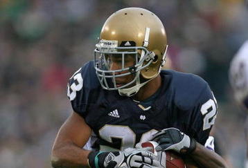 SOUTH BEND, IN - OCTOBER 03: Golden Tate #23 of the Notre Dame Fighting Irish attempts to break away from a Washington Huskie tackler on October 3, 2009 at Notre Dame Stadium in South Bend, Indiana. Notre Dame defeated Washington 37-30 in overtime. (Photo by Jonathan Daniel/Getty Images)