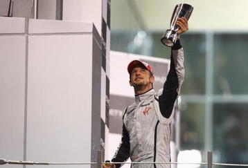 ABU DHABI, UNITED ARAB EMIRATES - NOVEMBER 01:  Jenson Button of Great Britain and Brawn GP celebrates on the podium after finishing third during the Abu Dhabi Formula One Grand Prix at the Yas Marina Circuit on November 1, 2009 in Abu Dhabi, United Arab Emirates.  (Photo by Paul Gilham/Getty Images)