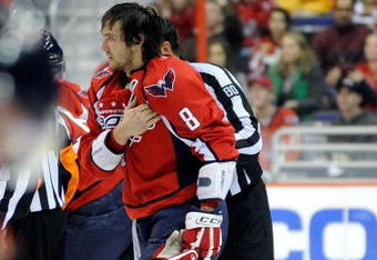 WASHINGTON - NOVEMBER 01:  Alex Ovechkin #8 of the Washington Capitals holds his shoulder as he is escorted to the penalty box after receiving a roughing penalty in the second period against the Columbus Blue Jackets at the Verizon Center on November 1, 2009 in Washington, DC.  (Photo by Greg Fiume/Getty Images)