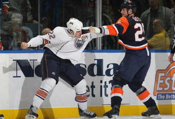 UNIONDALE, NY - NOVEMBER 02: Jean-Francois Jacques #22 of the Edmonton Oilers and Andy Sutton #25 of the New York Islanders square off at the Nassau Coliseum on November 2, 2009 in Uniondale, New York. (Photo by Bruce Bennett/Getty Images)