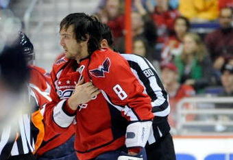 WASHINGTON - NOVEMBER 01:  Alex Ovechkin #8 of the Washington Capitals holds his shoulder as he is escorted to the penalty box after receiving a roughing penalty in the second period against the Columbus Blue Jackets at the Verizon Center on November 1, 2009 in Washington, DC.  (Photo by Greg Fiume/Getty Images)