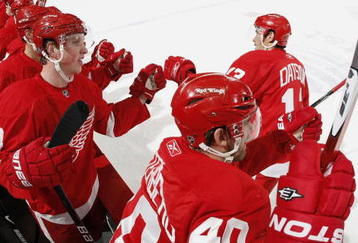 DETROIT - NOVEMBER 03:  Pavel Datsyuk #13 of the Detroit Red Wings celebrates a first period Tomas Holmstrom goal with Henrik Zetterberg #40, Justin Abdelkader #8 and the rest of the bench while playing the Boston Bruins on November 3, 2009 at Joe Louis Arena in Detroit, Michigan.  (Photo by Gregory Shamus/Getty Images)