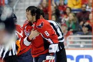 WASHINGTON - NOVEMBER 01:  Alex Ovechkin #8 of the Washington Capitals holds his shoulder as he is escorted to the penalty box after receiving a roughing penalty in the second period against the Columbus Blue Jackets at the Verizon Center on November 1, 2009 in Washington, DC.  (Photo by Greg Fiume/Getty Images)