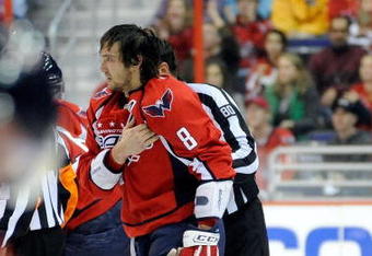WASHINGTON - NOVEMBER 01:  Alex Ovechkin #8 of the Washington Capitals holds his shoulder as he is escorted to the penalty box after receiving a roughing penalty in the second period against the Columbus Blue Jackets at the Verizon Center on November 1, 2009 in Washington, DC.  (Photo by Greg Fiume/Getty Images)