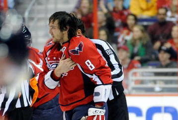 WASHINGTON - NOVEMBER 01:  Alex Ovechkin #8 of the Washington Capitals holds his shoulder as he is escorted to the penalty box after receiving a roughing penalty in the second period against the Columbus Blue Jackets at the Verizon Center on November 1, 2009 in Washington, DC.  (Photo by Greg Fiume/Getty Images)