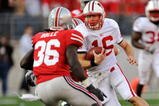 COLUMBUS, OH - OCTOBER 10:  Quarterback Scott Tolzien #16 of the Wisconsin Badgers looks for running room as Brian Rolle #36 of the Ohio State Buckeyes closes in for the tackle at Ohio Stadium on October 10, 2009 in Columbus, Ohio.  (Photo by Jamie Sabau/Getty Images)