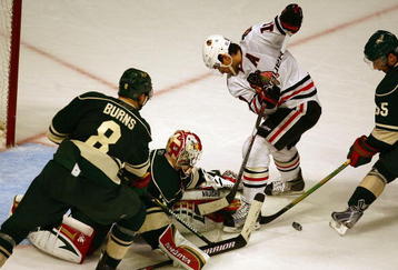CHICAGO - OCTOBER 26: Niklas Backstrom #32 of the Minnesota Wild falls to knock the puck away from Patrick Sharp #10 of the Chicago Blackhawks as Brent Burns #8 and Nick Schultz #55 defend at the United Center on October 26, 2009 in Chicago, Illinois. The Blackhawks defeated the Wild 3-1. (Photo by Jonathan Daniel/Getty Images)
